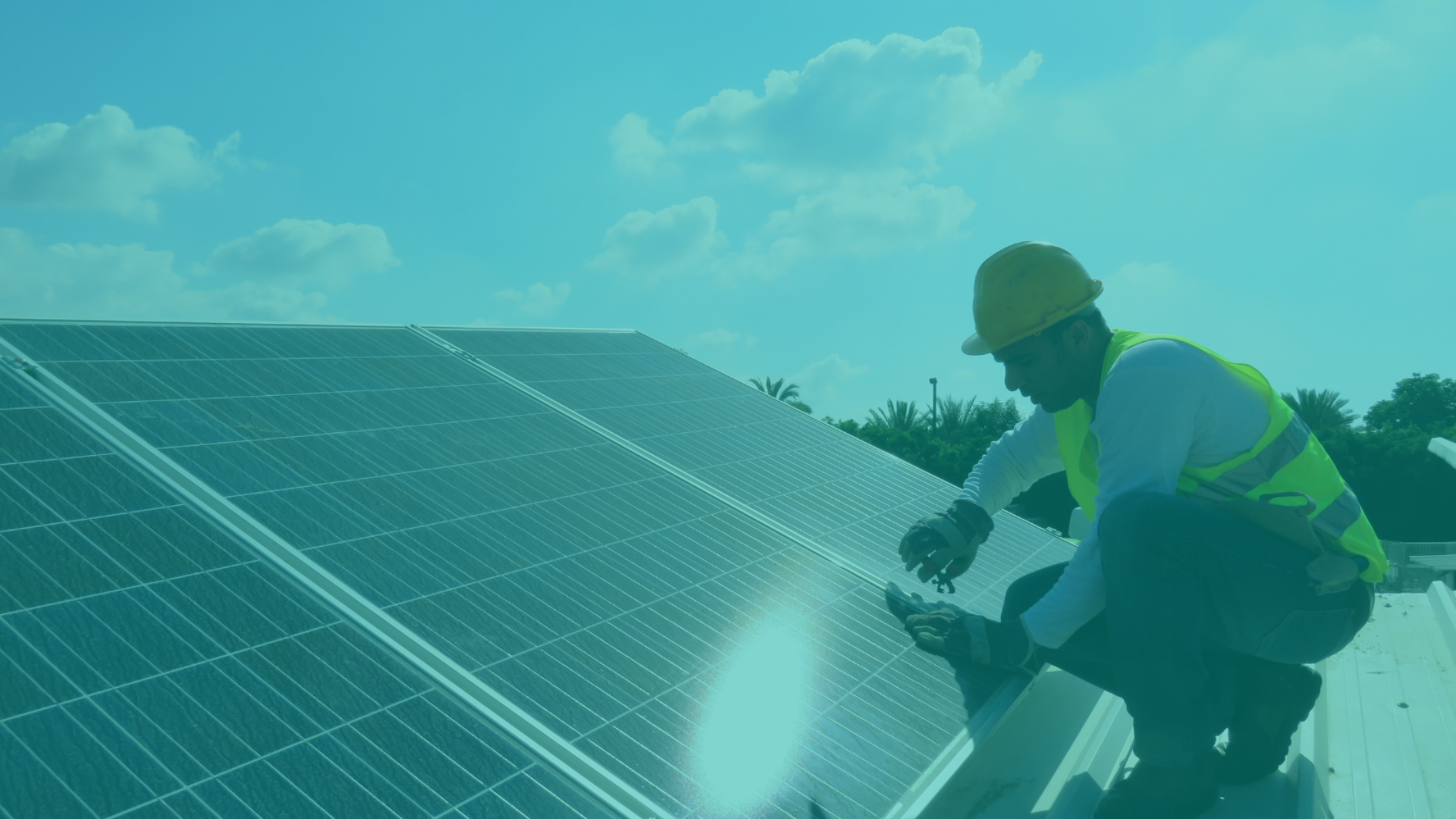 An image of a man wearing a hard hat and yellow high vis jacket fitting solar panels on a roof